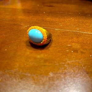 Women’s gold colored ring with blue and orange stones